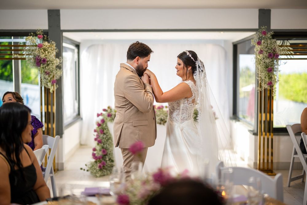A couple shares their first dance at an elegant wedding reception decorated with purple floral arrangements.