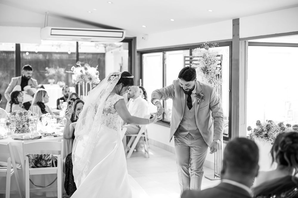 Wedding moments captured in black and white photography show special interactions between guests at a reception.