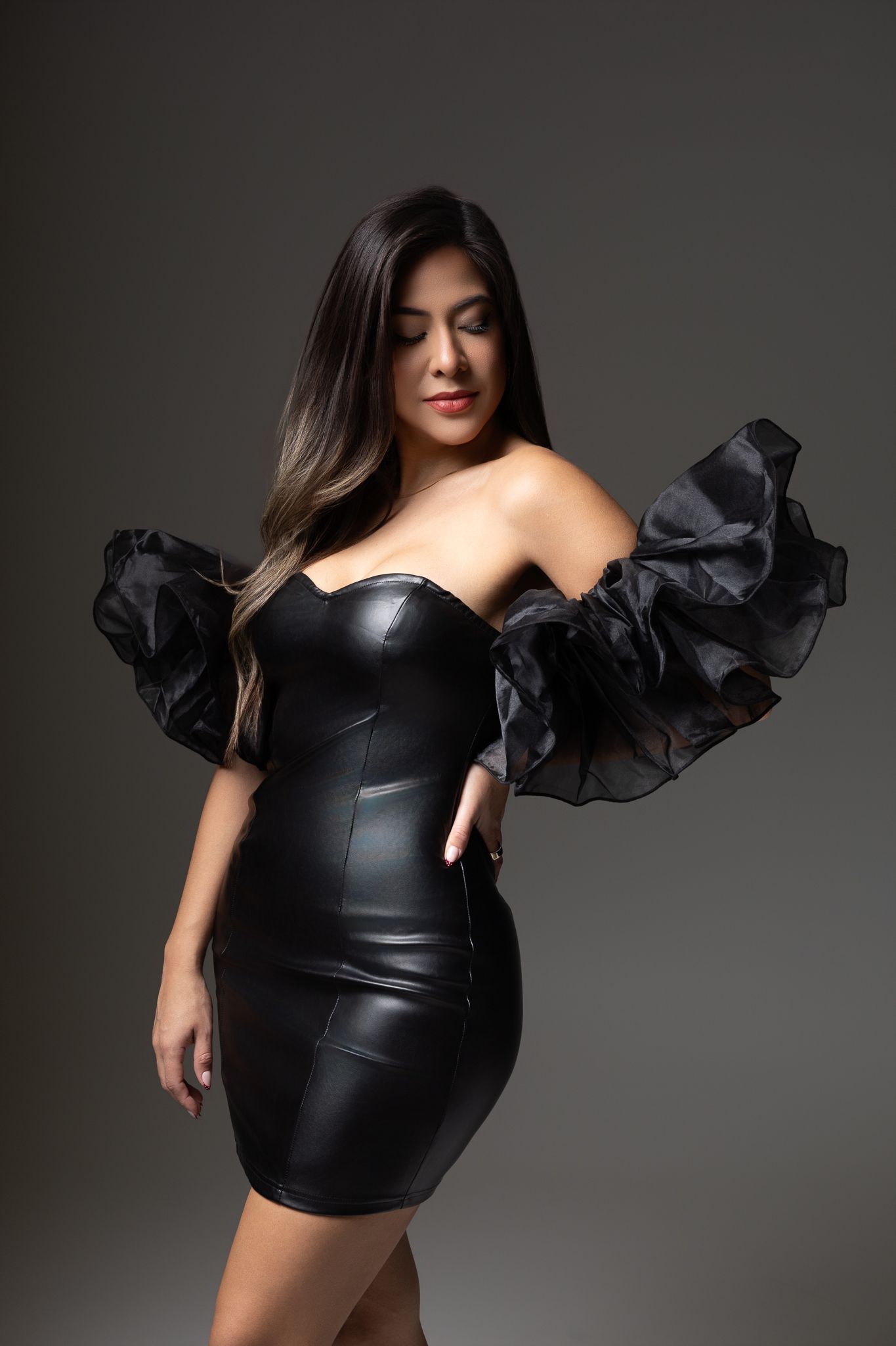 Fashion photography series showing black leather and tulle dress against dark gray studio backdrop.
