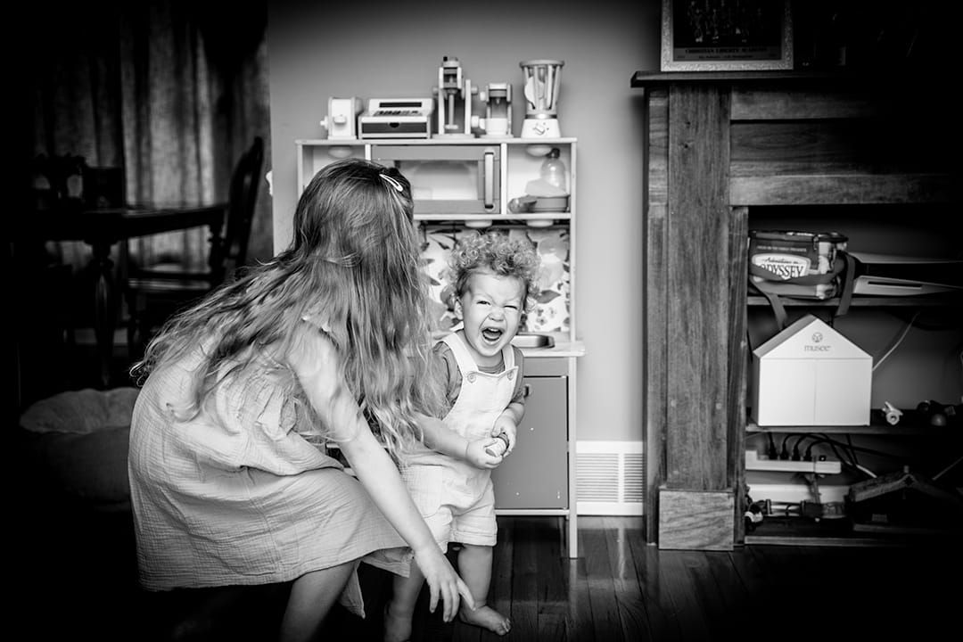A tender black and white moment captured between two people in a cozy living room setting during a lifestyle session in Palatine.