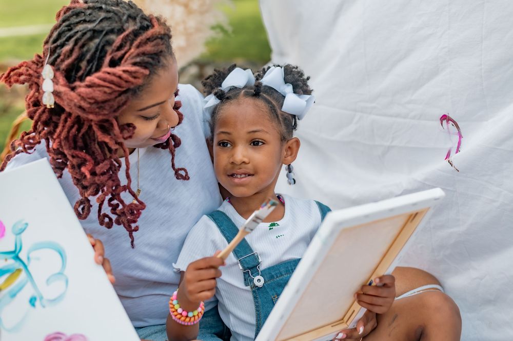 Children sitting at table with paper and art supplies engage in creative drawing activities during arts and crafts.