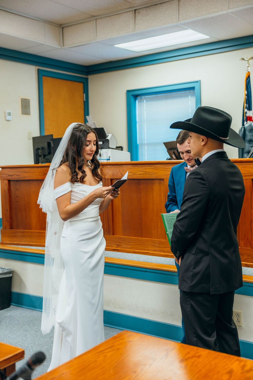 A playful wedding moment captured in a courthouse setting with bright turquoise accents.