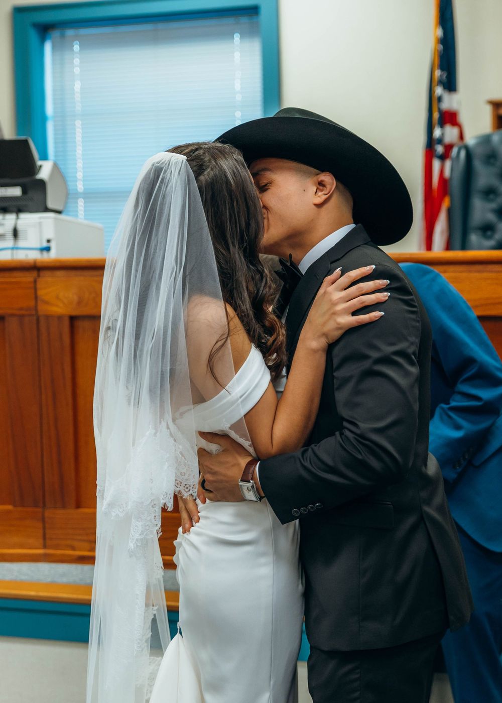 A romantic wedding moment captured in an indoor setting with fluorescent lighting. North Carolina.
