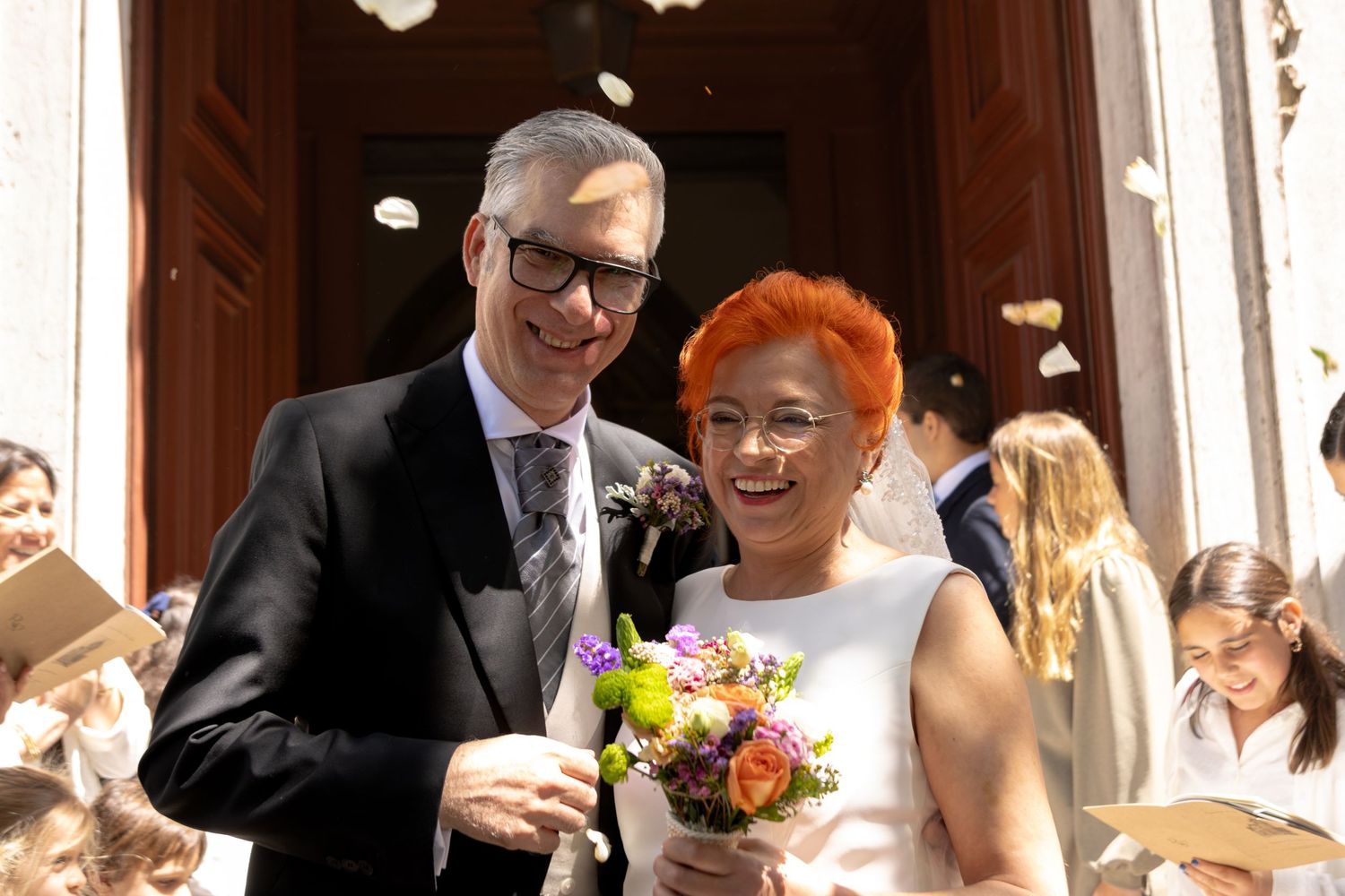 A celebratory wedding moment with confetti falling outside a church entrance.