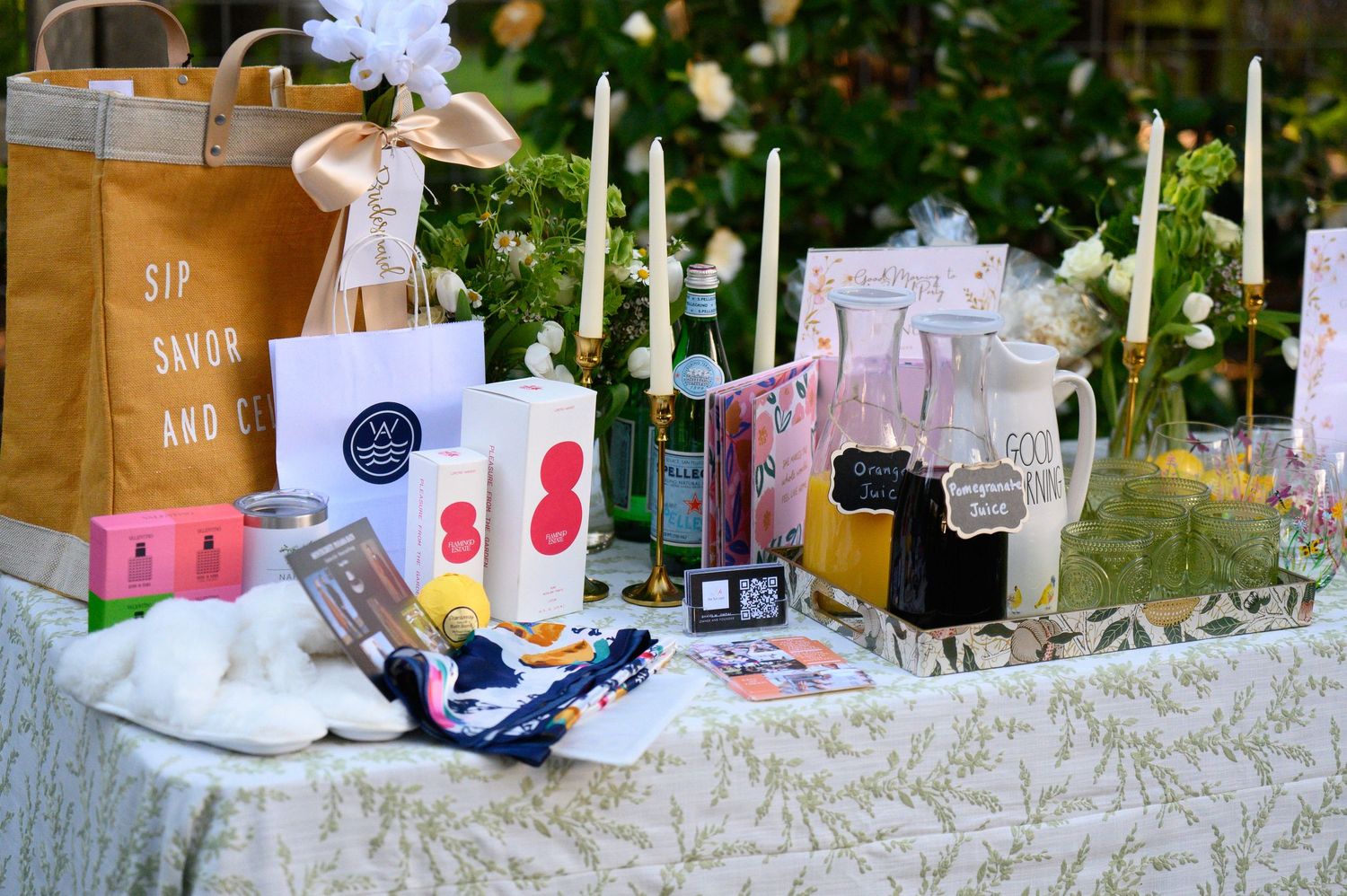 An elegantly styled wedding table with rustic paper bags, candles, and beverage jars on a white lace tablecloth, designed by Fun Cart Events