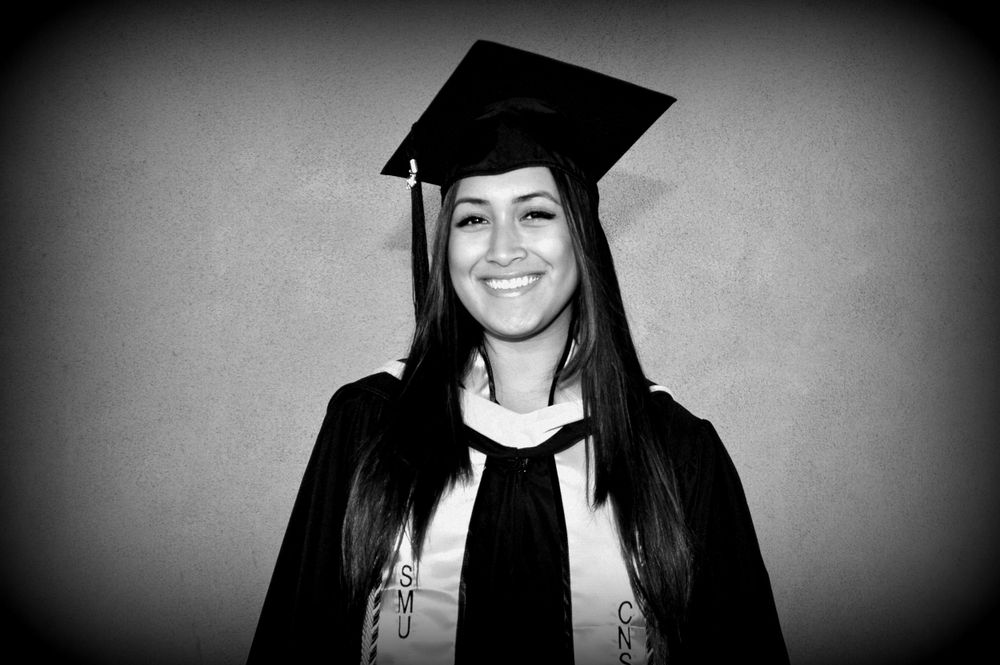 Black and white graduation portrait with traditional cap and gown.