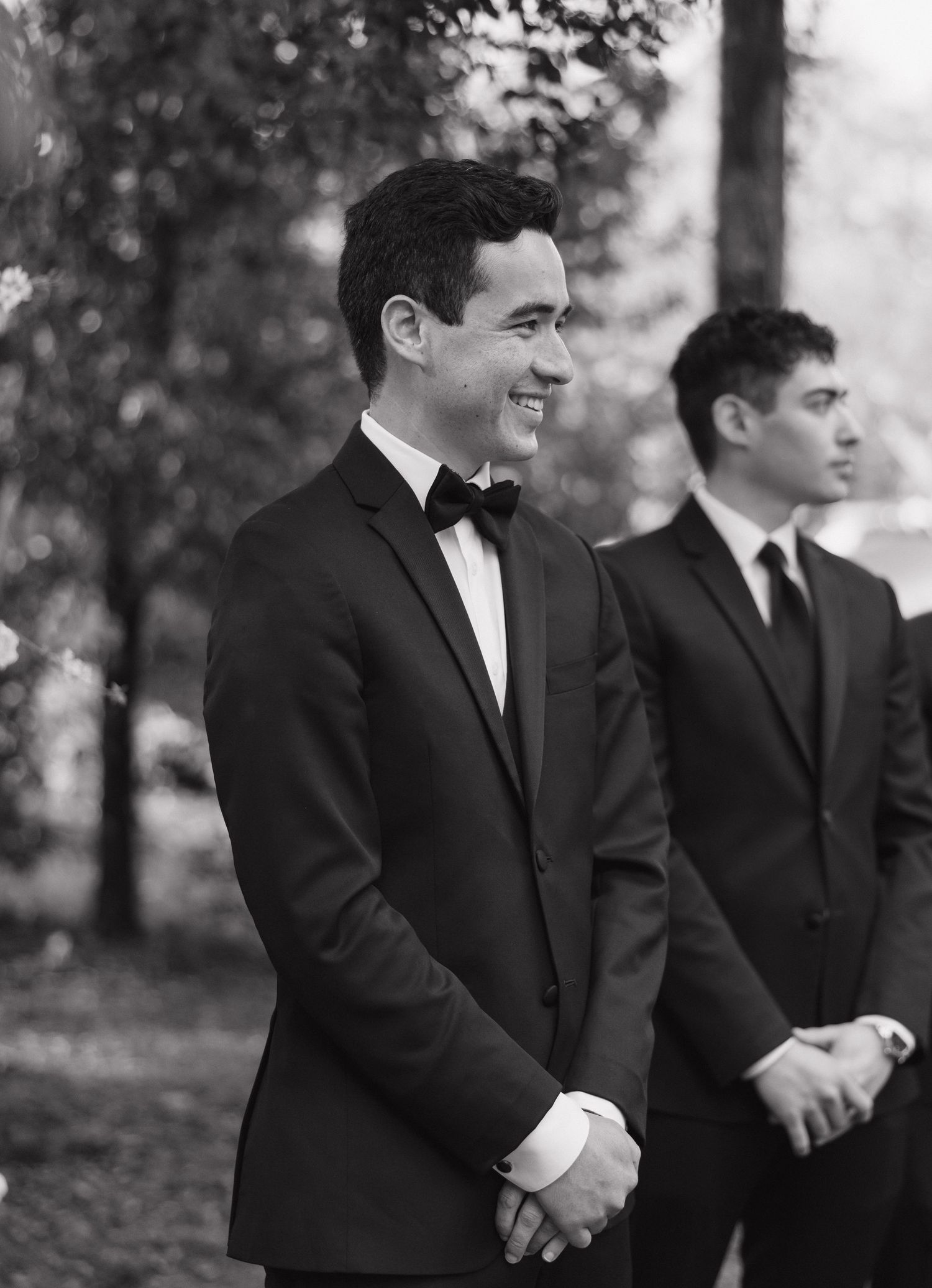 A series of black and white photos showing groomsmen in formal suits standing together outdoors.