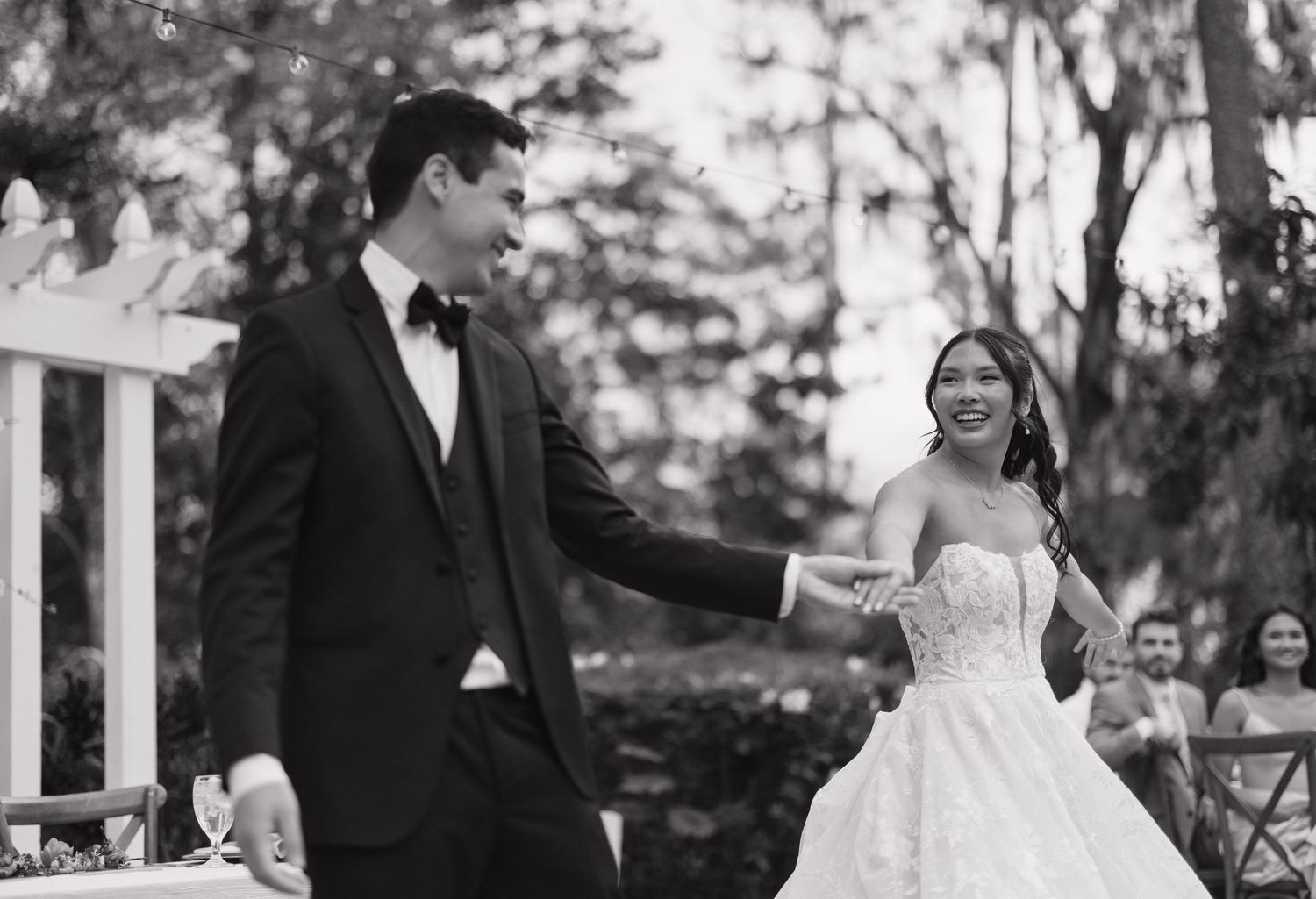 A bride and groom share a romantic dance together during their outdoor wedding reception.