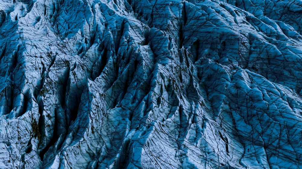 Abstract blue rock formations with deep ridges and textures create a dramatic natural pattern.
