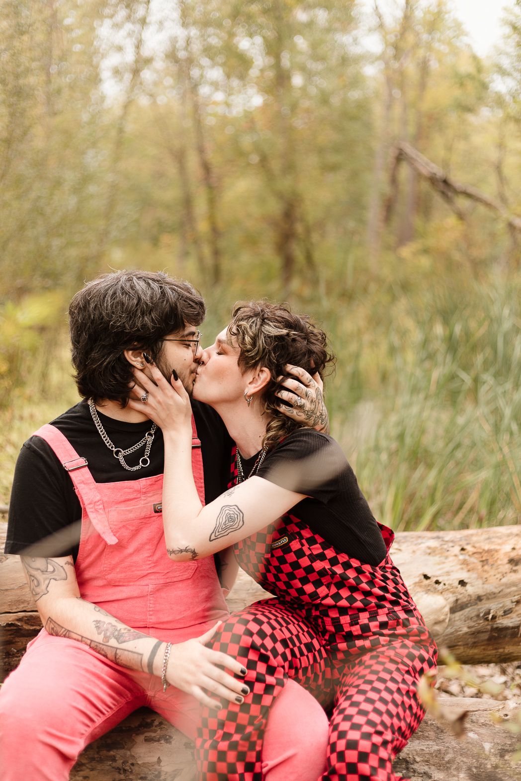 A romantic autumn scene with two people sharing an intimate moment on a fallen log.