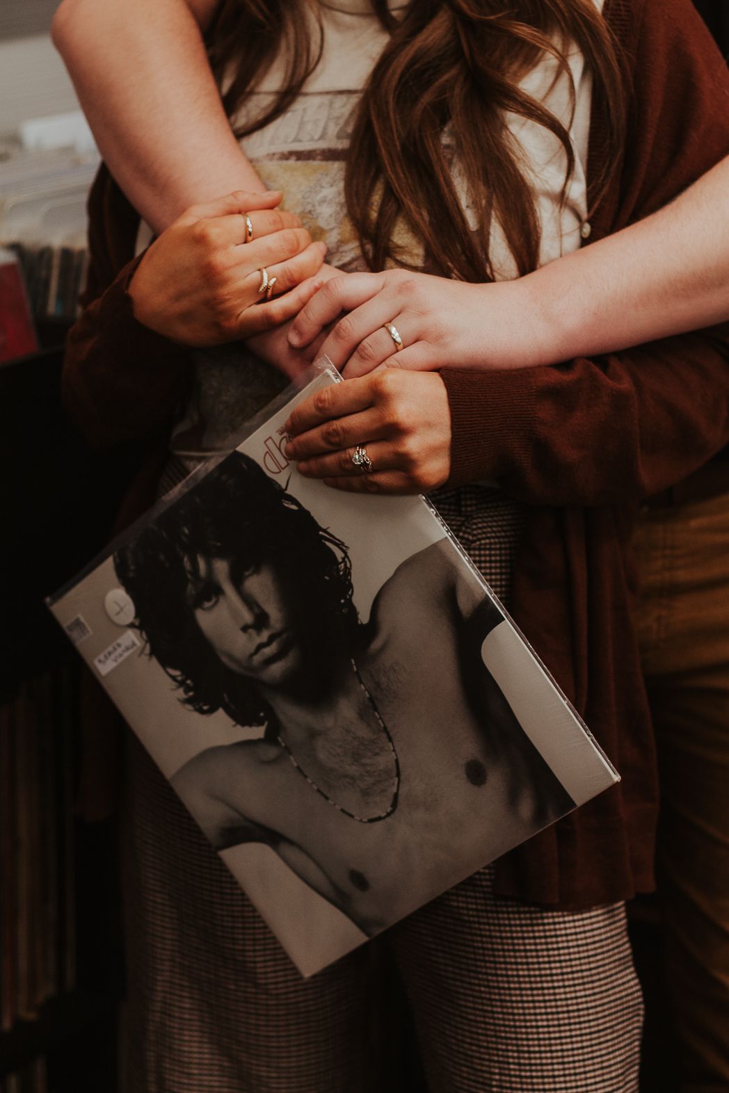 Hands holding vintage Jim Morrison vinyl record album in indoor setting.