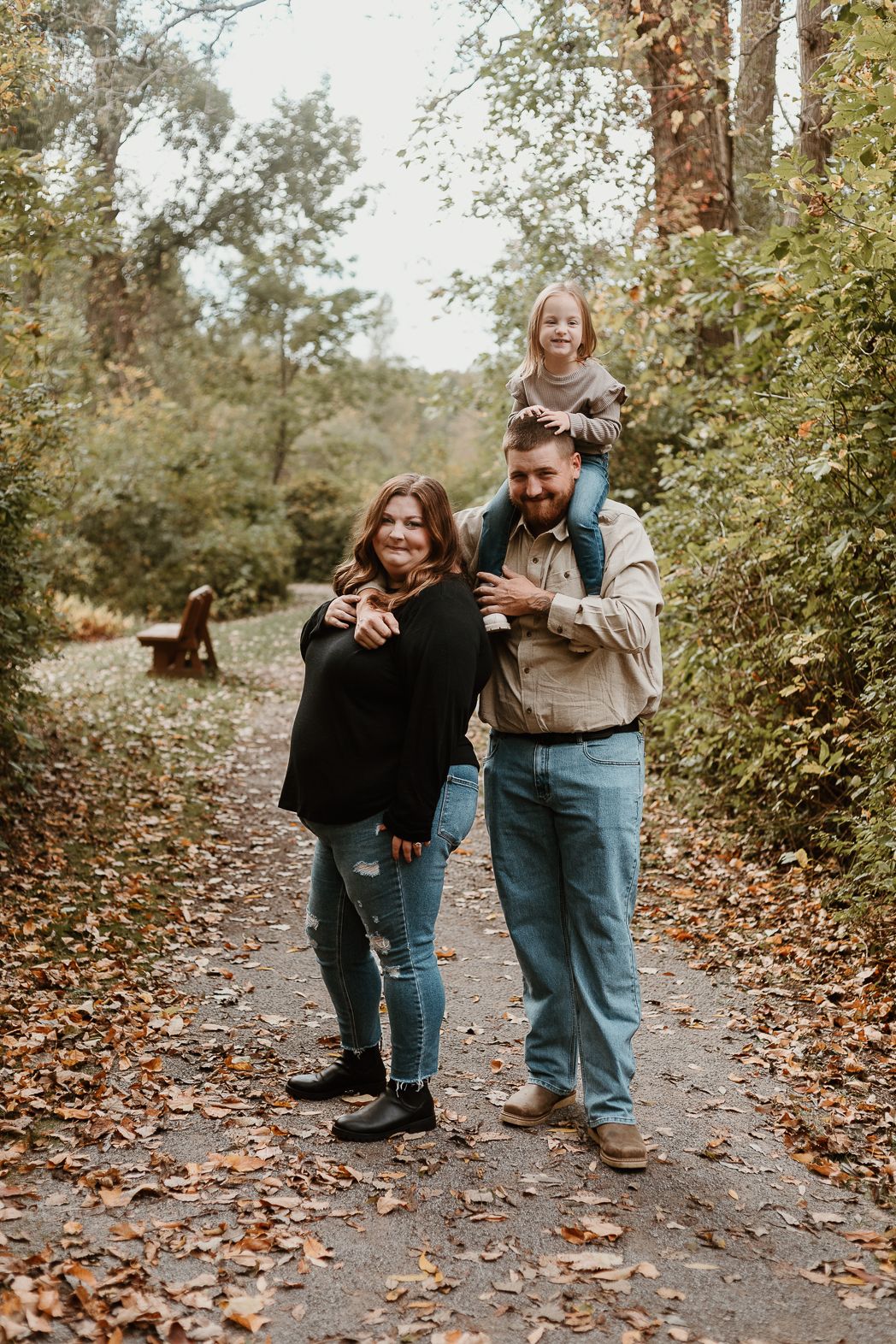 Playful autumn photoshoot sequence on a leaf-covered path through the woods.