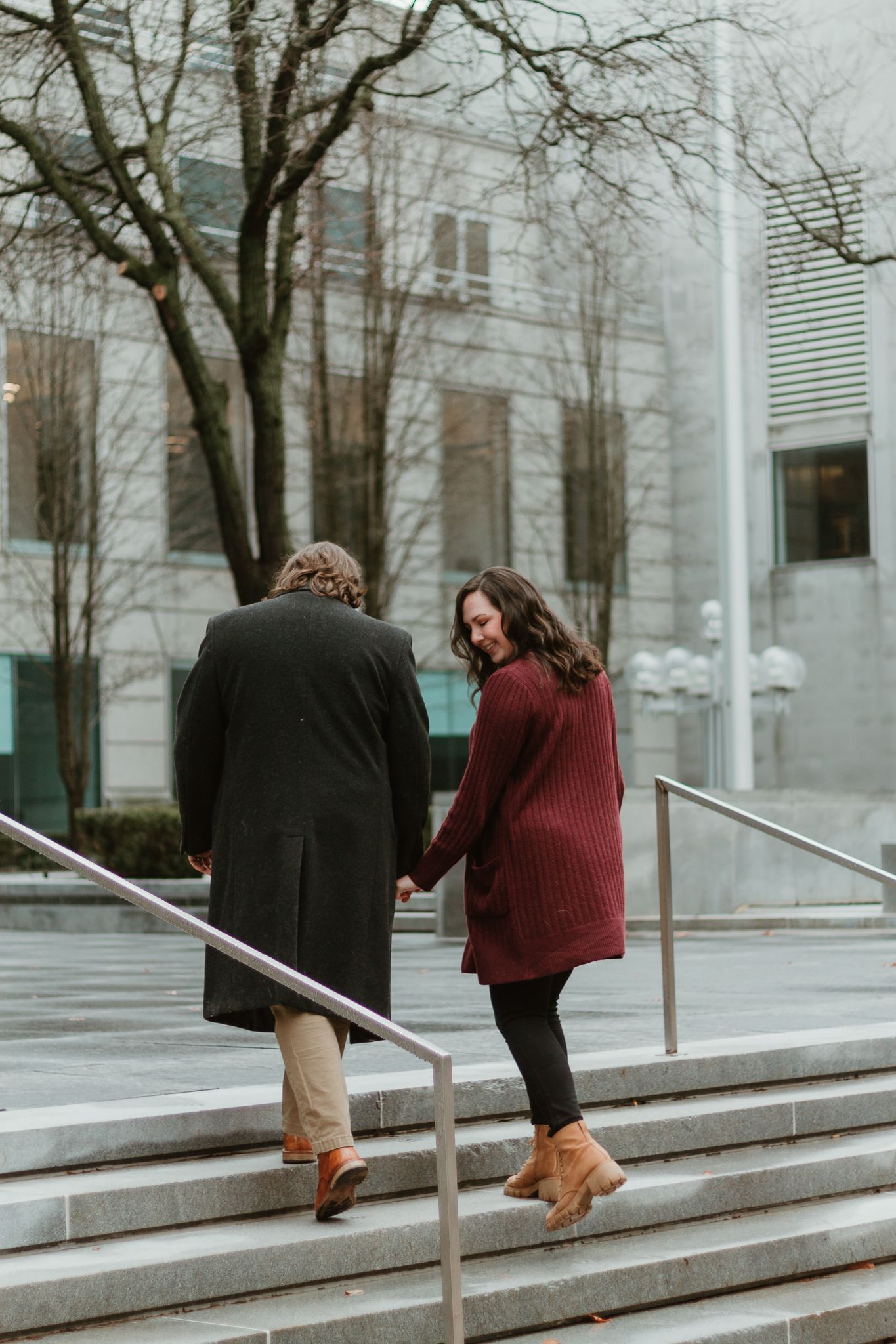 Two people walking down stone steps in winter wearing coats.
