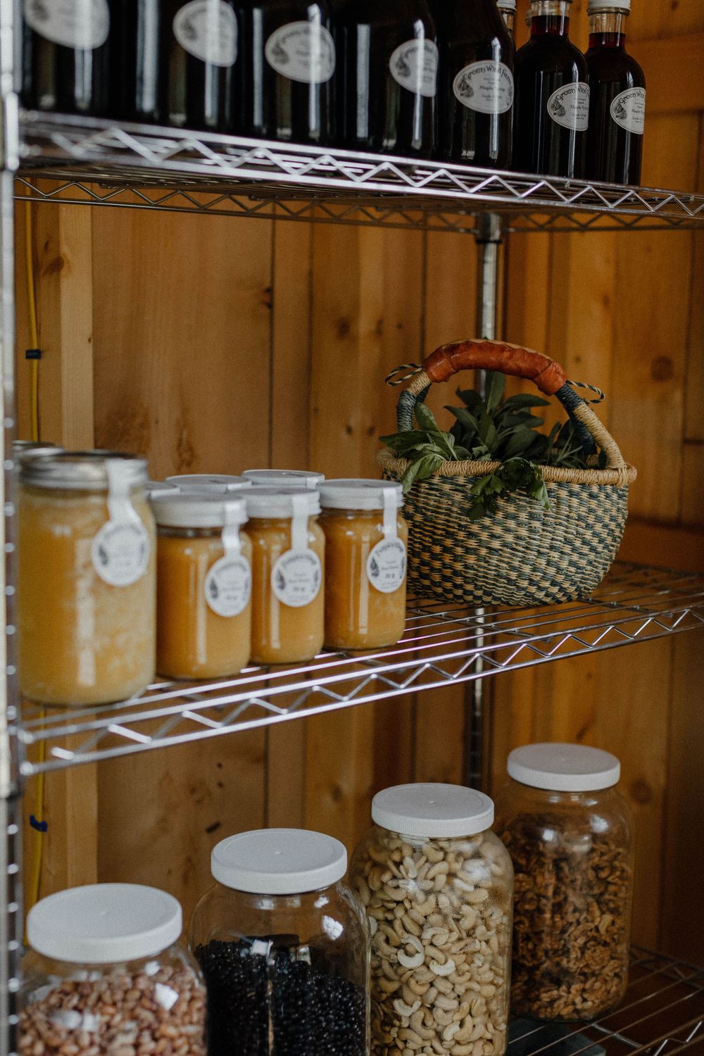Organized pantry shelves with glass jars of preserved foods and ingredients.