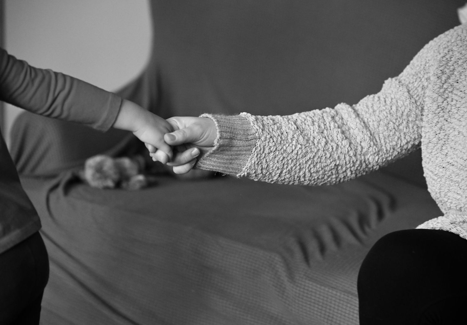 A black and white photo of Amber holding Emma's hand