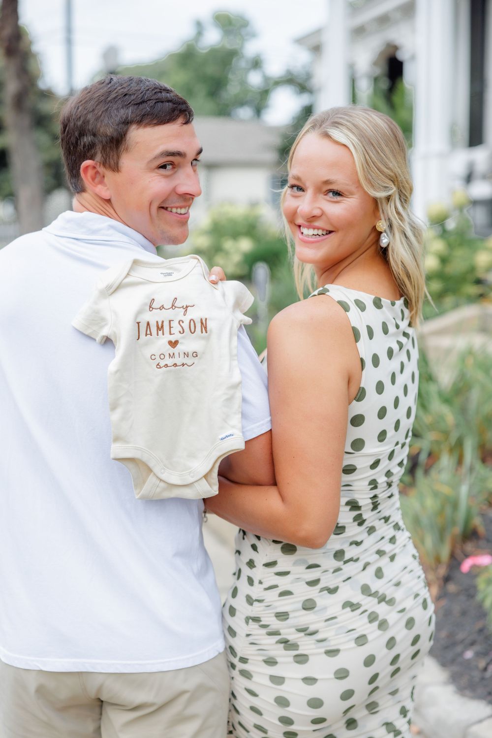 Outdoor pregnancy announcement photoshoot in polka dot dress.