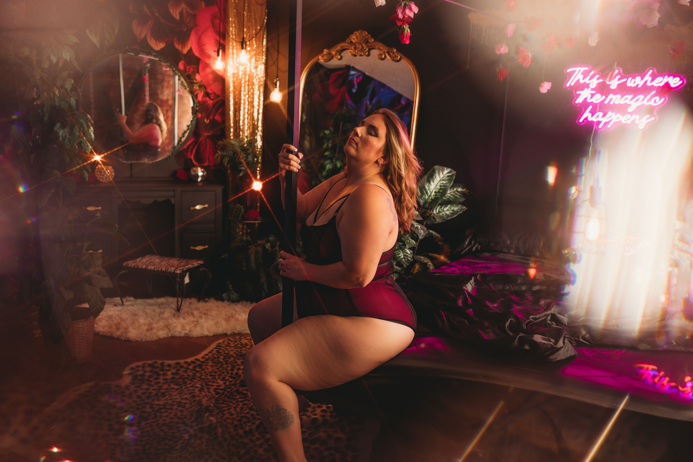 A neon-lit indoor scene with a woman posing near decorative lights and tropical plants in a moody atmosphere.