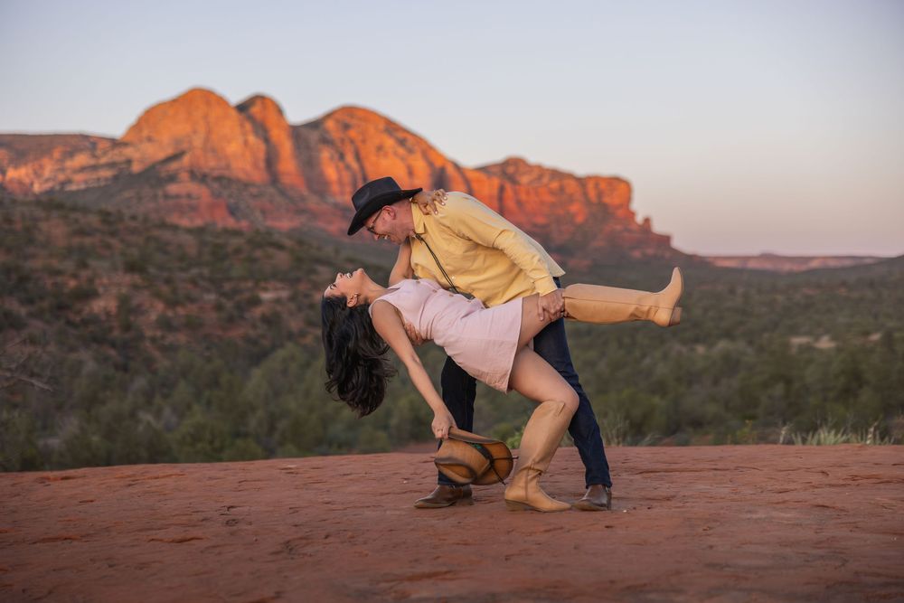Couple dancing at sunset with red rock formations in Sedona, Arizona background.
