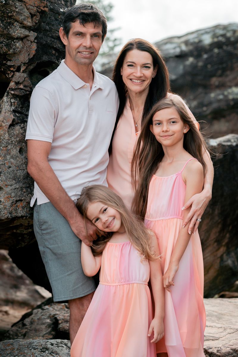 Family photoshoot at freshwater beach with a family of four smiling happily