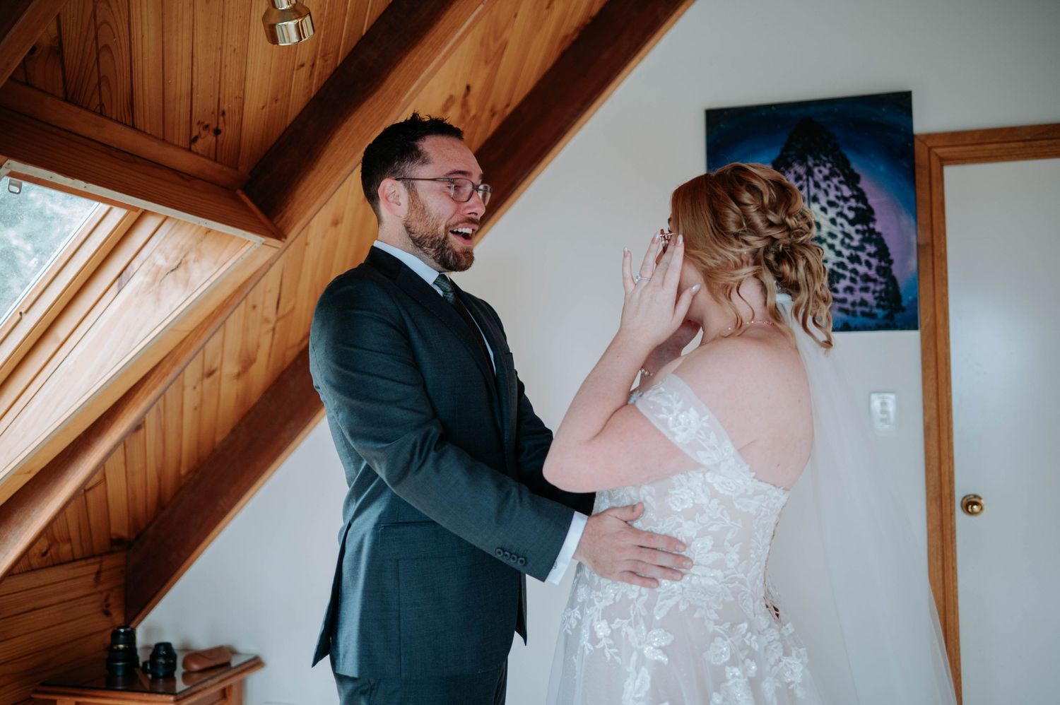 An emotional wedding moment shared between newlyweds in a rustic cabin setting.