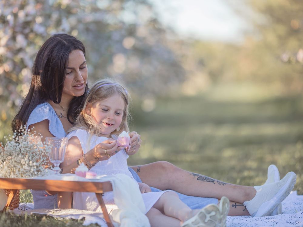 Mamma och barn vid blommande träd i kvällsljus, familjefotografering Västerås. MemoriebyM