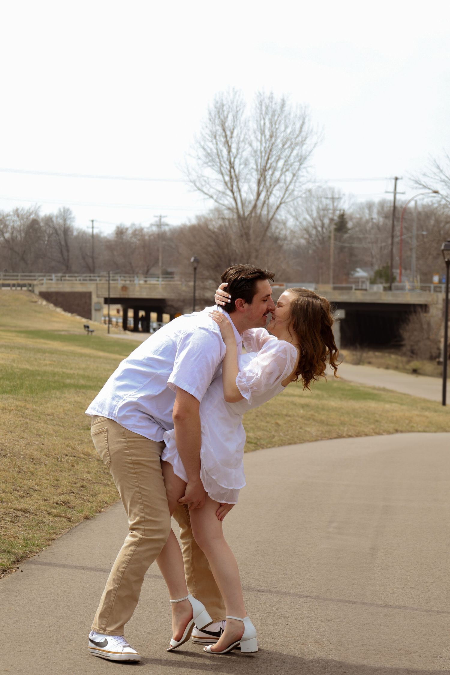 Couple sharing romantic moment on paved path.