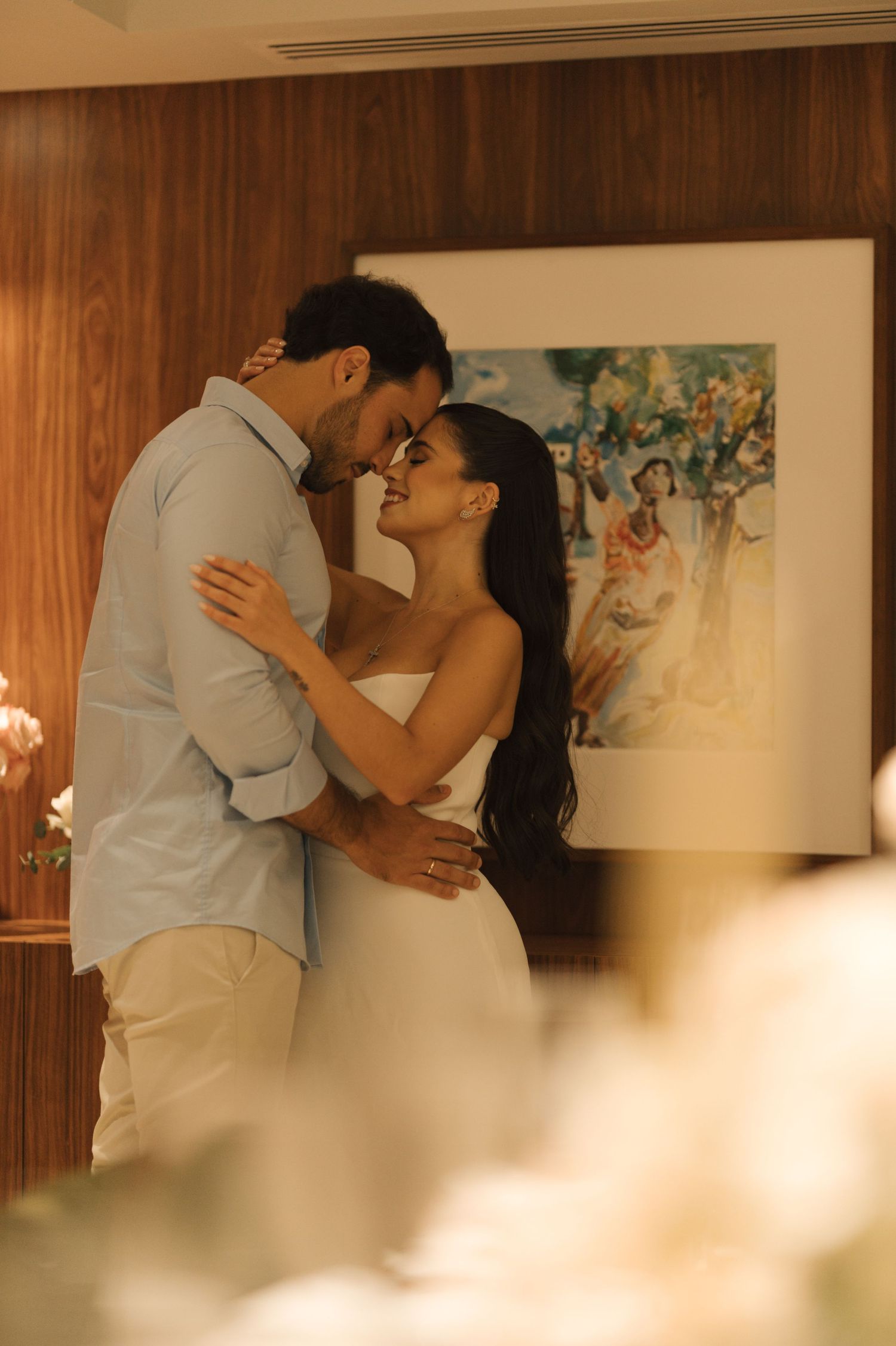 Romantic couple in casual wedding attire sharing an intimate moment against brick archways.