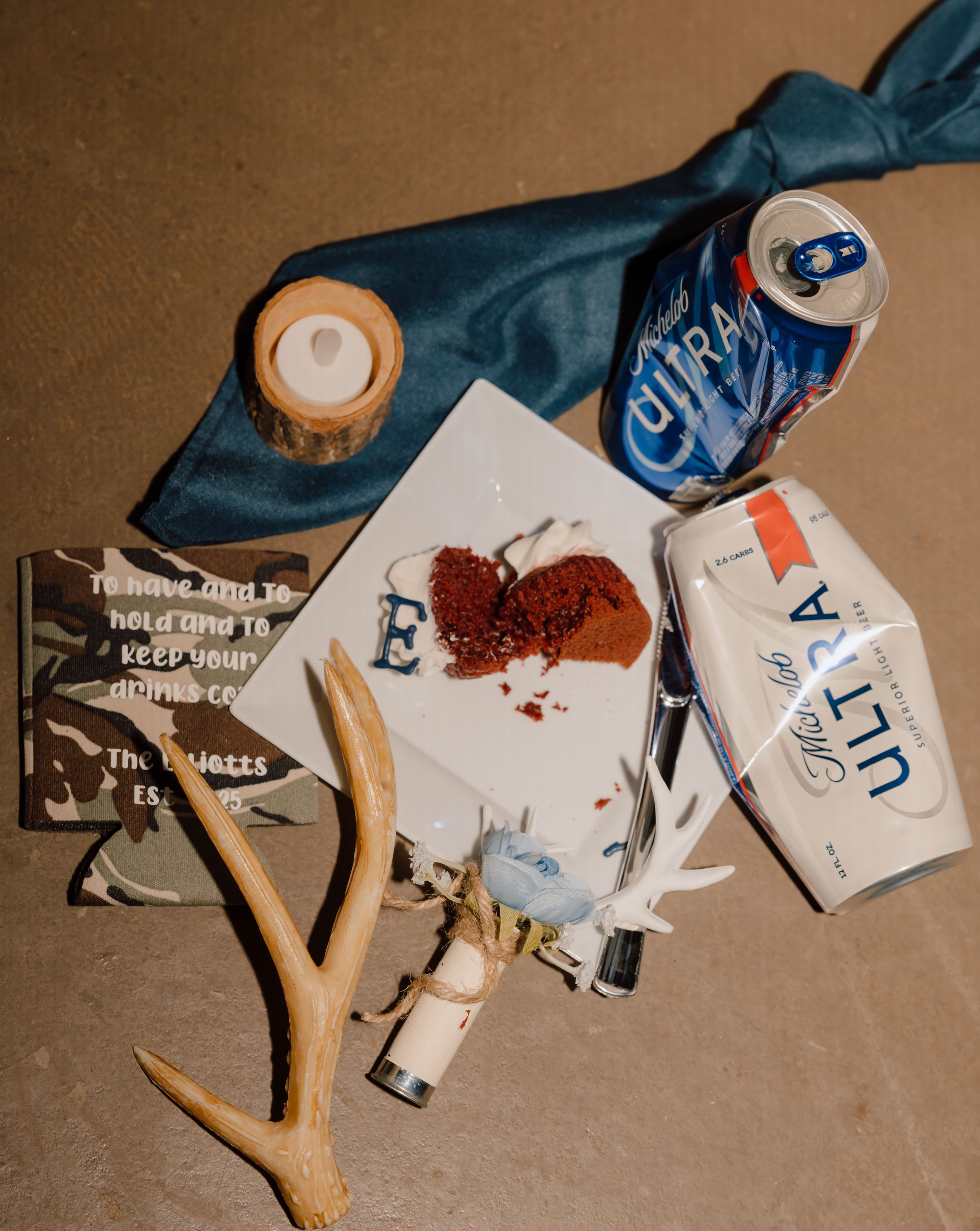 Scattered alcohol, cigarette, and drug items arranged on brown paper with a wooden slingshot or decorative ornament.