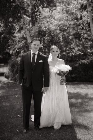 A black and white wedding photo series showing a couple walking together outdoors in formal attire.