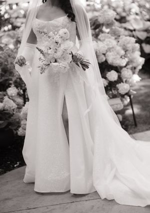 Black and white wedding photograph series showing the flowing details of an elegant white bridal gown and floral arrangements.