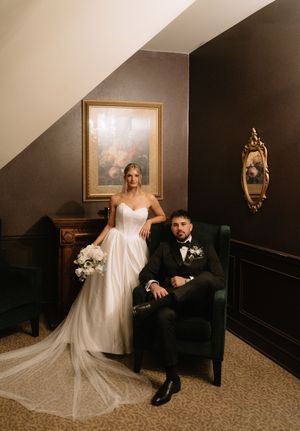Elegant wedding couple poses in a formal indoor setting with dark walls and vintage decor in a series of romantic portraits.