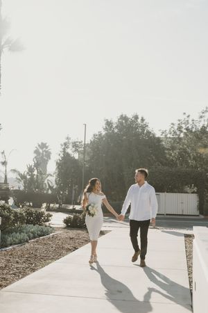 Sunlit walkway photos showing playful moments between a couple.