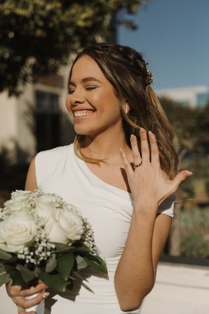 Candid bride portraits with white roses and natural sunlight.