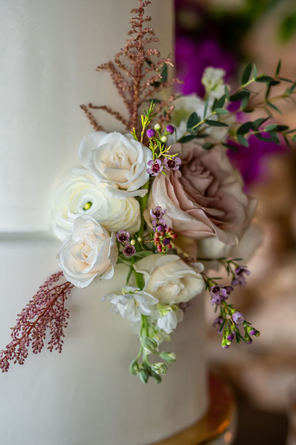 Long elegant wedding table setting with floral centerpieces and gold chairs on a covered outdoor patio.