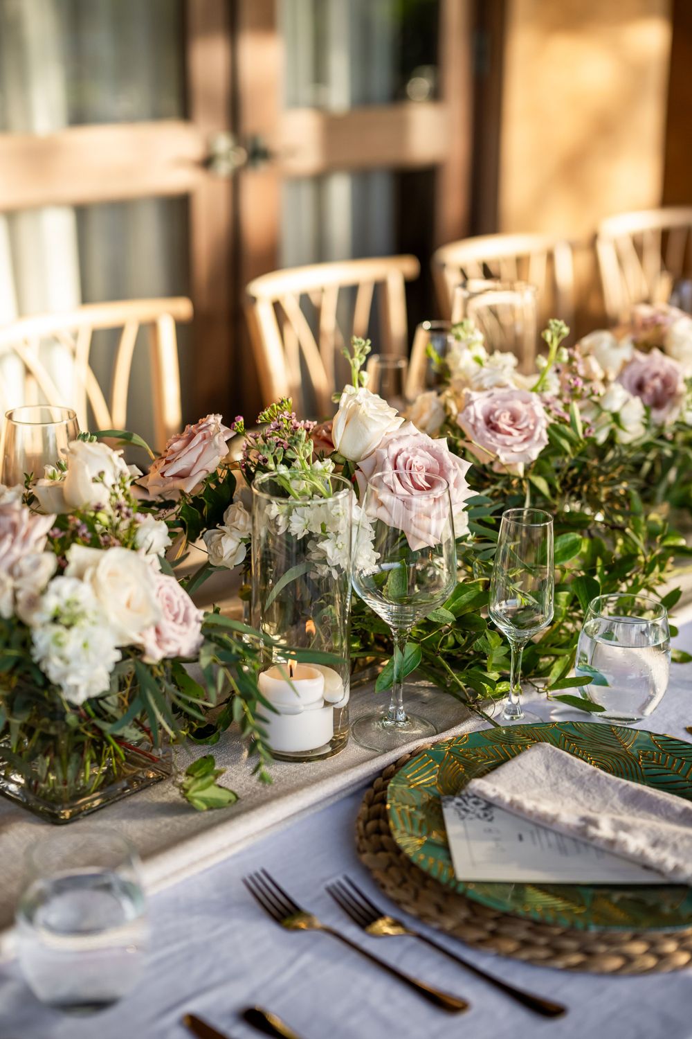 Decorative wooden shelf display with bright pink bougainvillea flowers and white roses in glass vases.