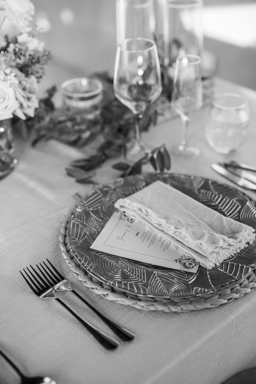 Elegant black and white table setting with menu card and decorative plate at an upscale event.