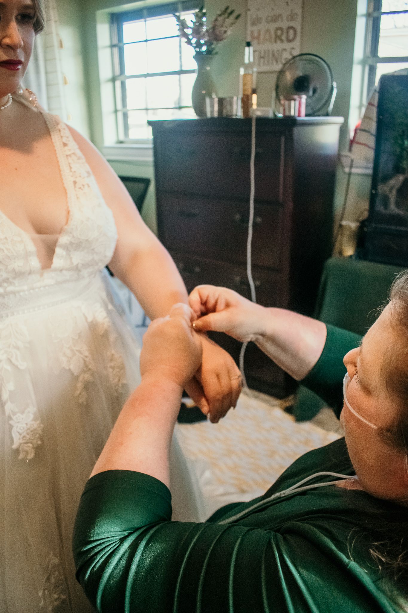 Close-up of wedding dress details being adjusted during preparation.