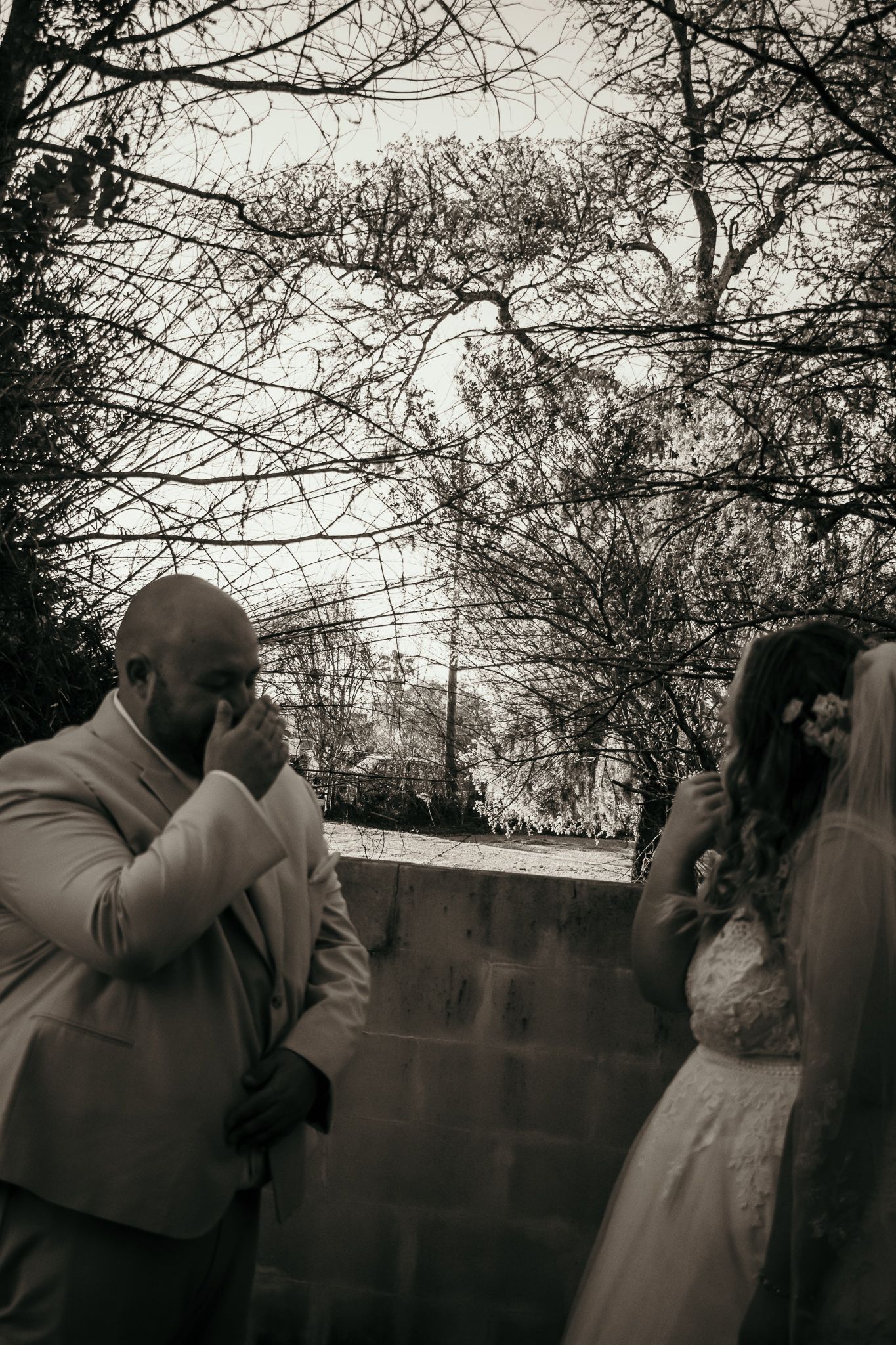 A black and white emotional moment captured during an outdoor wedding ceremony.