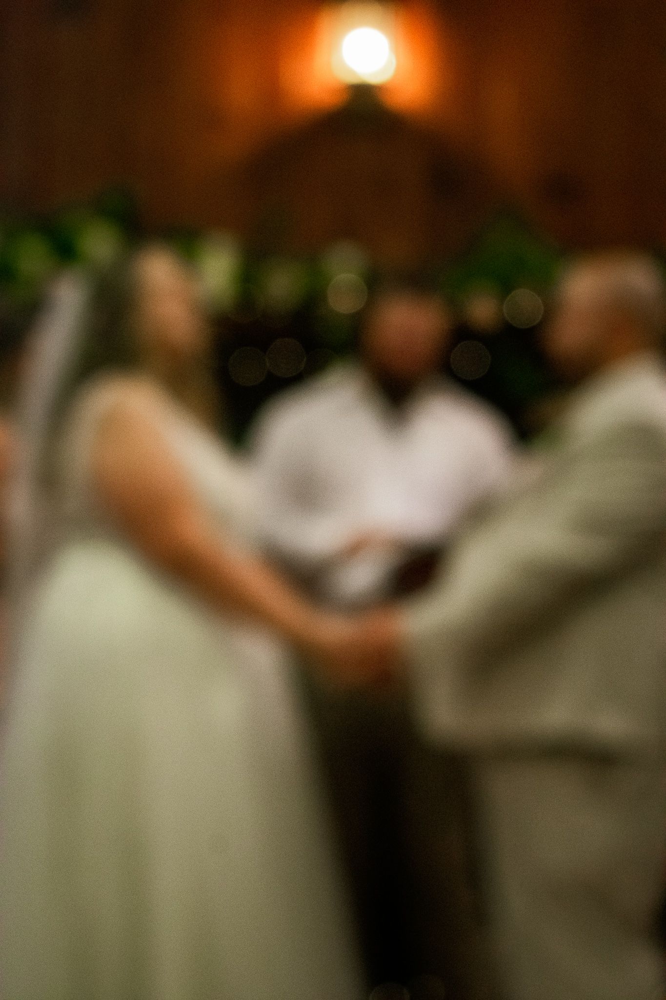 A soft focus capture of an intimate wedding ceremony moment with warm ambient lighting.