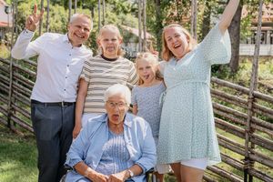 Busigt och personligt foto med tre generationer under en stor familjsfotografering