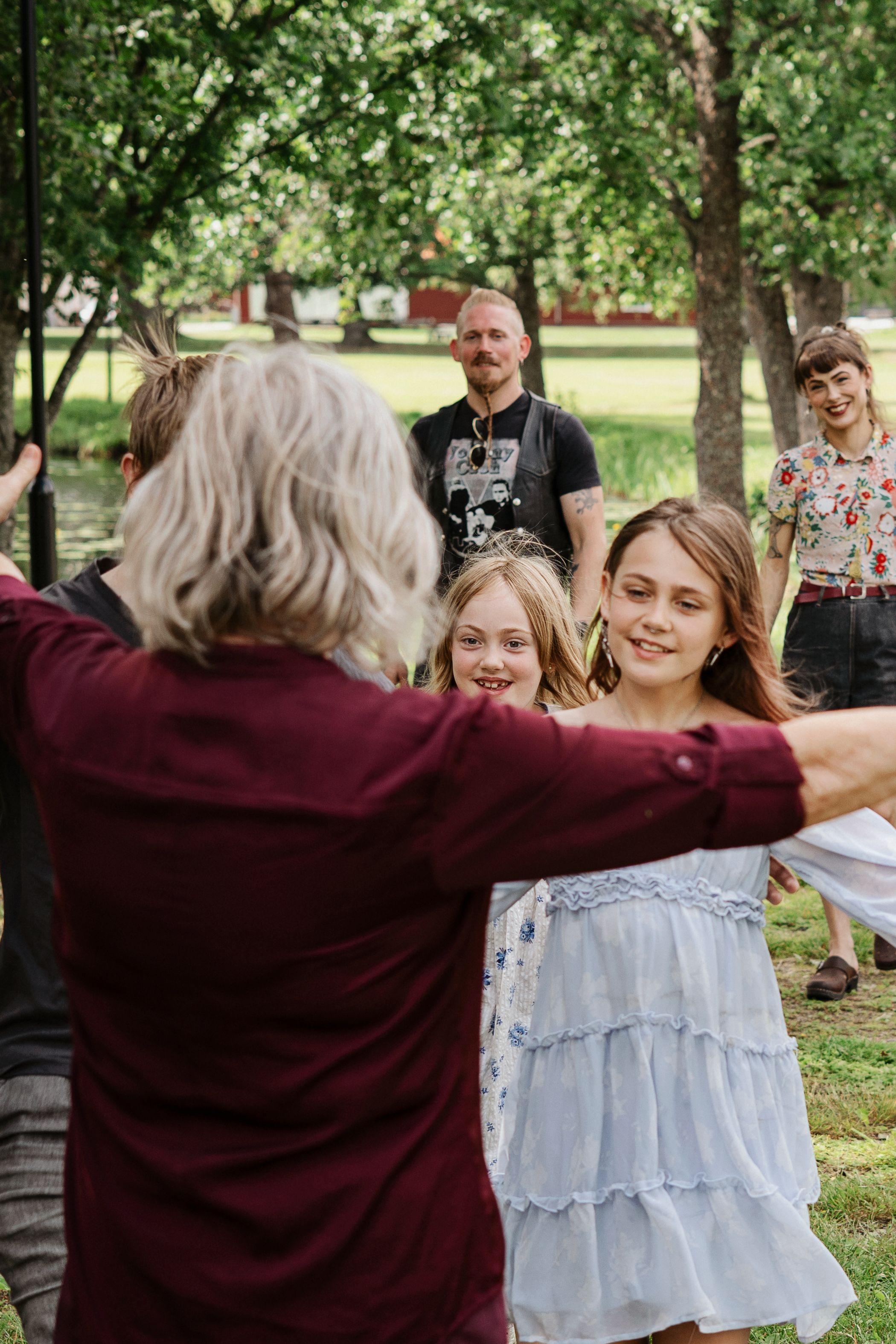 Lekfull familjefotografering utomhus i Sandviken med barn och vuxna tillsammans.