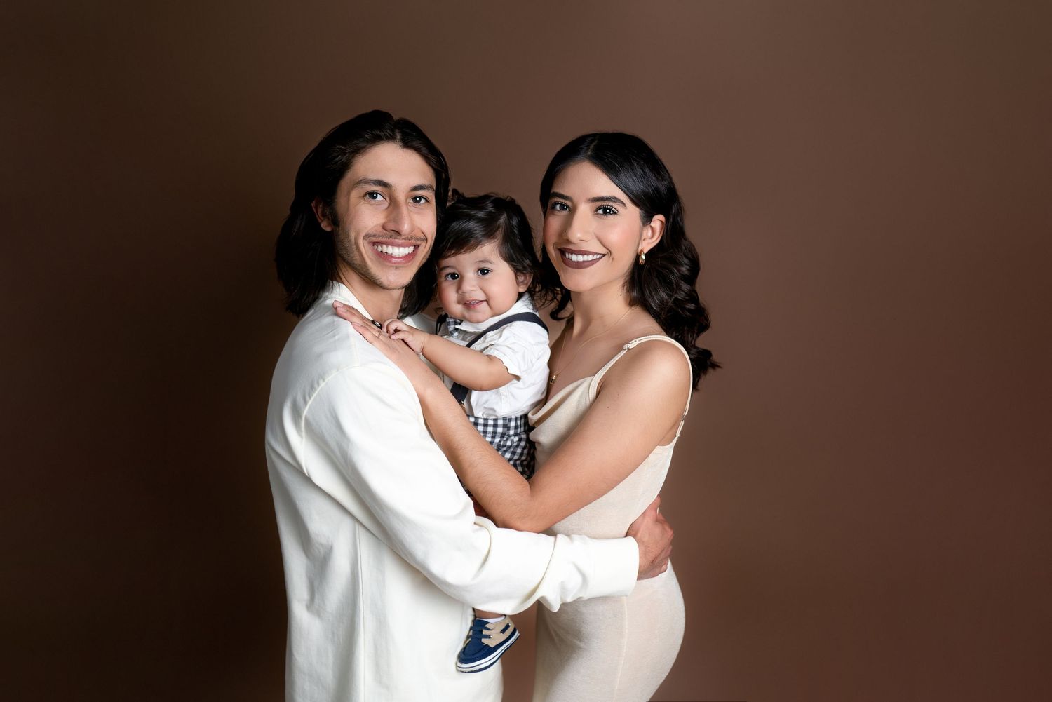 Young family with baby posing together for a studio family portrait in Covina, California by Ester Nguyen Photography.