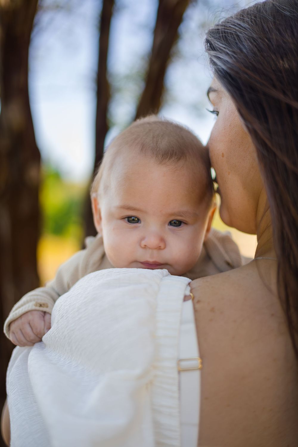 An un-staged and tender close-up of a mother cuddling her baby during a natural light lifestyle session in Central Texas.
