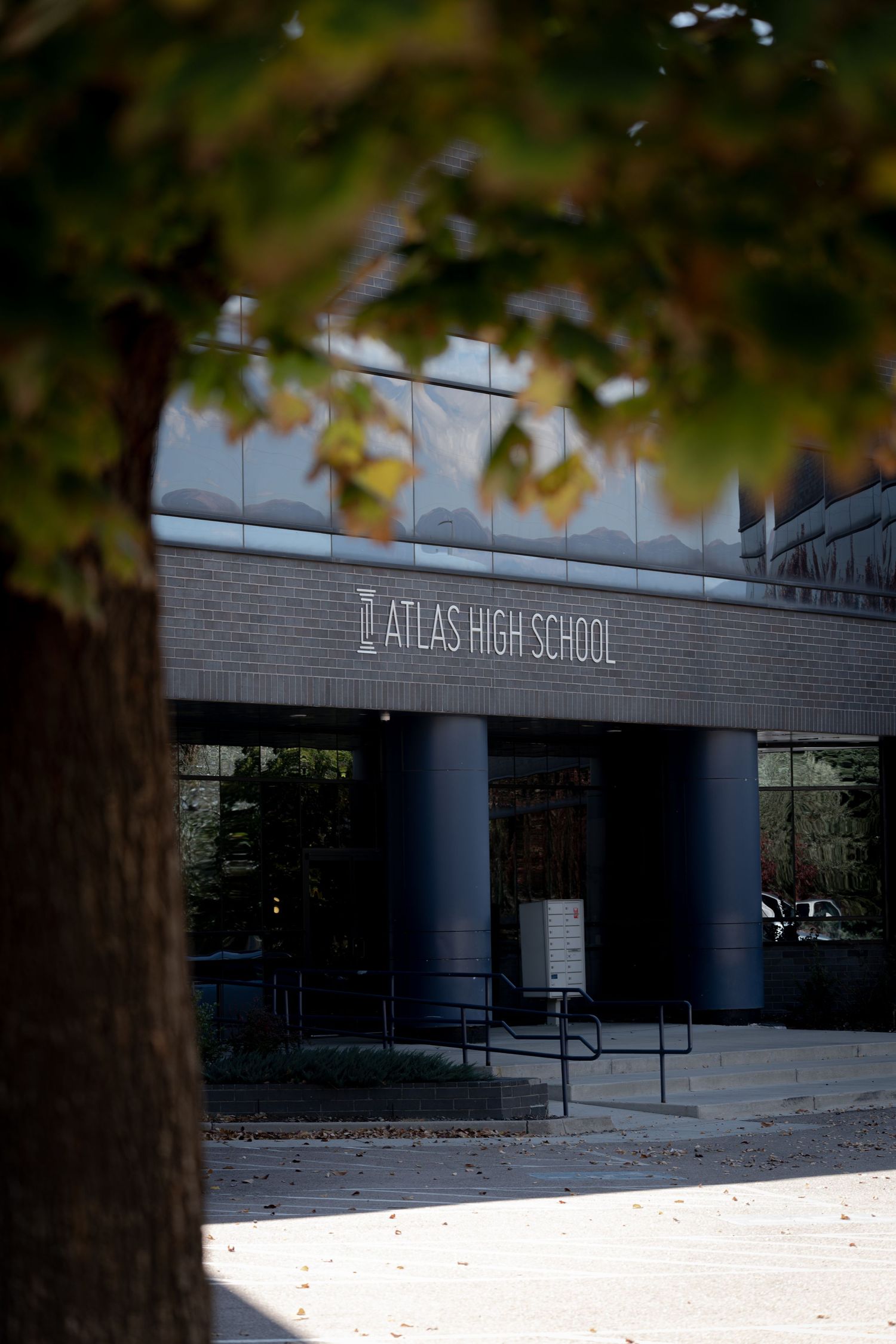 Exterior view of Atlas High School entrance with modern architectural columns and signage.