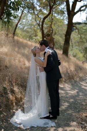 Romantic wedding photo sequence of a couple embracing on a sunlit nature trail.