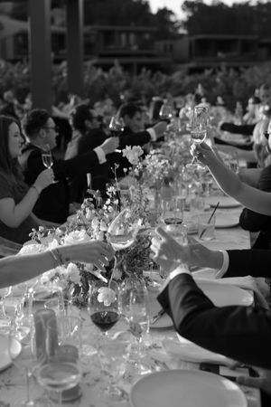 Long banquet table with wine glasses and floral arrangements glowing in evening light.