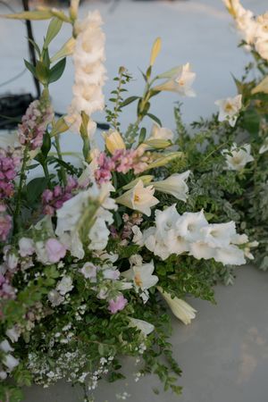 Delicate floral centerpiece featuring white snapdragons, pink stock flowers, and fresh greenery on display.