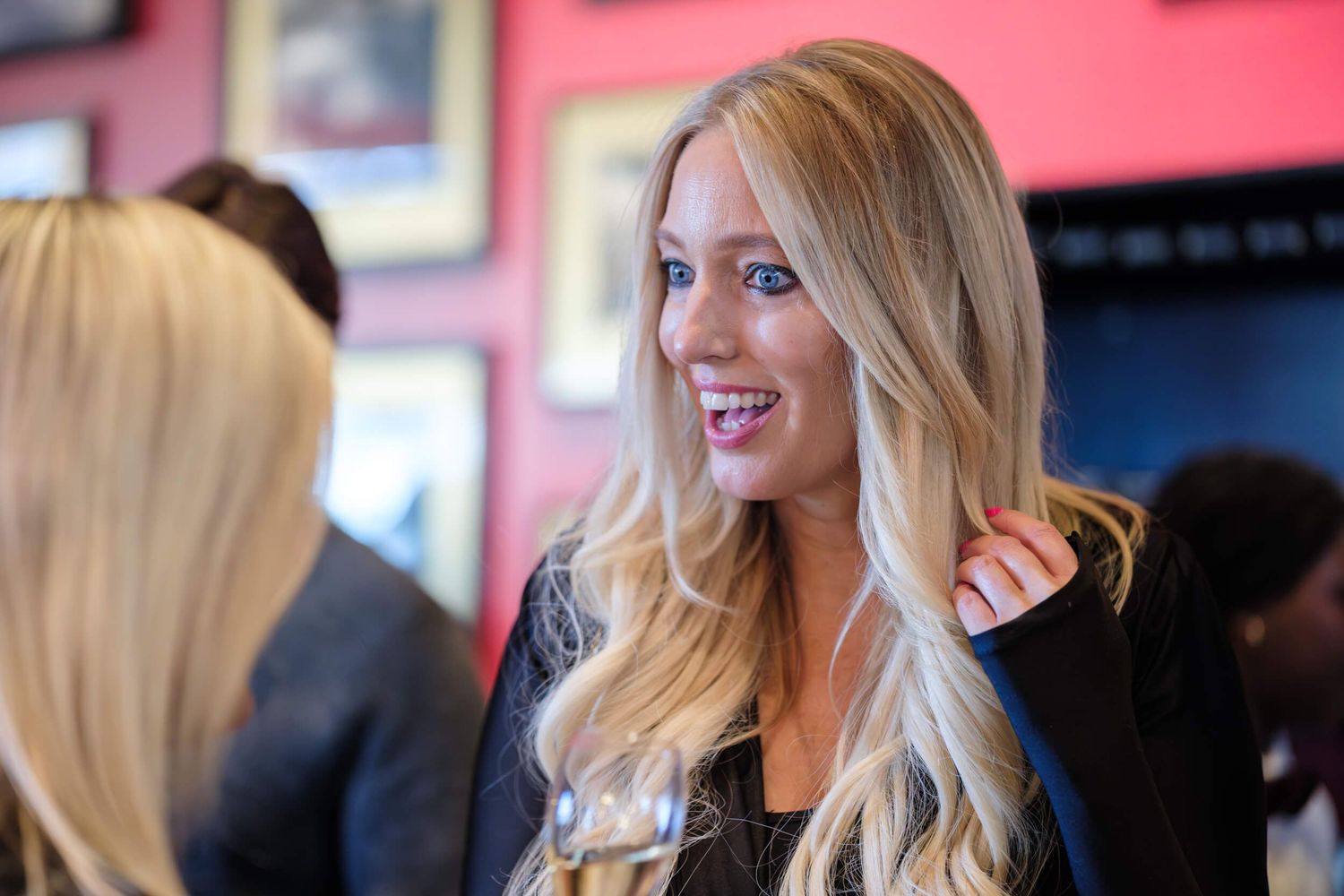 A woman with long blonde hair smiles while wearing a black top in a series of similar candid shots.