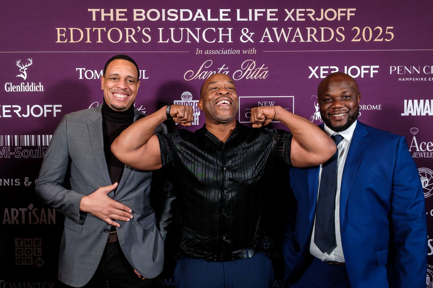 People posing together at the Boisdale Life XeJoff Edition's Lunch and Awards 2025 event against a purple backdrop.