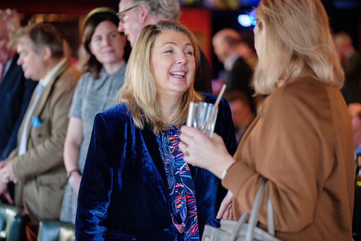People enjoying conversation and drinks at an elegant indoor event.